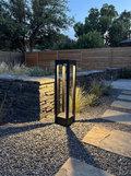 GOODNEST SLATE square bollard in a modern gravel courtyard