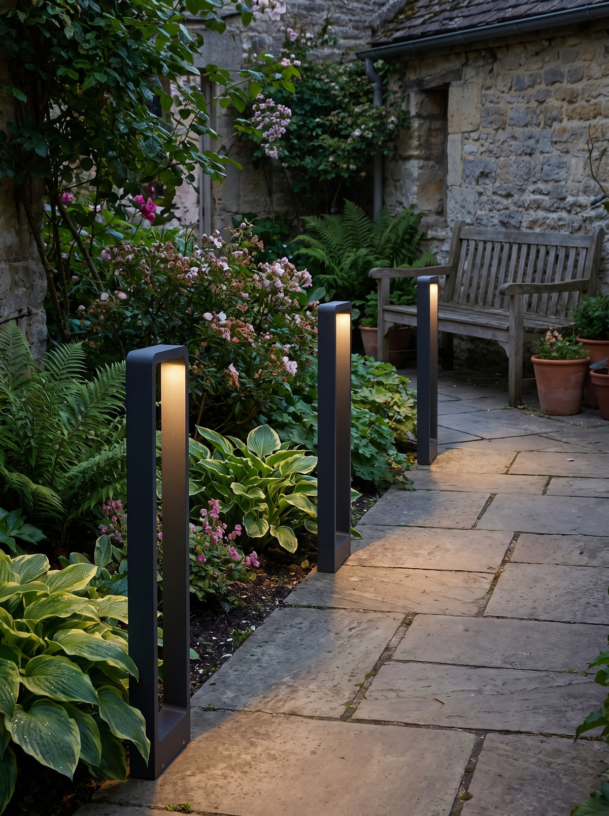 GOODNEST MERIDIAN bollard marking a planting bed in a courtyard