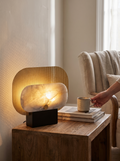 GOODNEST SEAM perforated golden panel lamp glowing on a desk